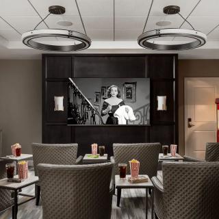 A cozy home theater setup with comfortable seating, showing a black and white film on the screen.