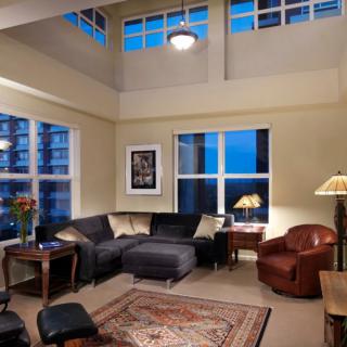 A cozy and well-lit living room with modern furnishings and large windows.
