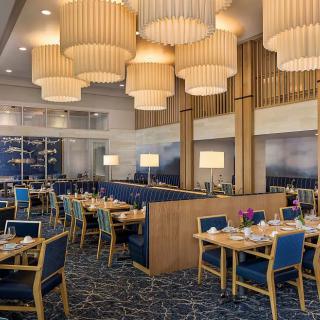 A modern restaurant interior with elegant lighting and neatly arranged tables.