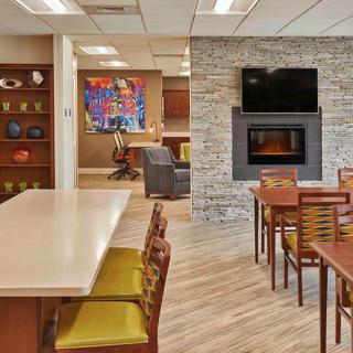 A modern lounge area featuring a dining setup, a fireplace, and a mounted television.