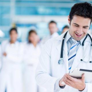 A group of doctors, with one in focus using a tablet.