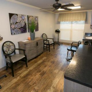 A modern waiting room with chairs, artwork, and a wooden floor.