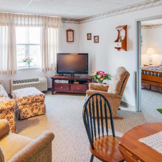 A cozy living room with a television, comfortable seating, and homey decor.