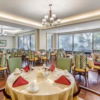An elegant dining room with neatly arranged tables and chairs, featuring a sophisticated interior design.