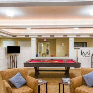 A stylish game room featuring a red pool table and comfortable seating.
