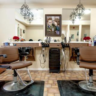 A cozy barbershop interior with stylish chairs and mirrors.