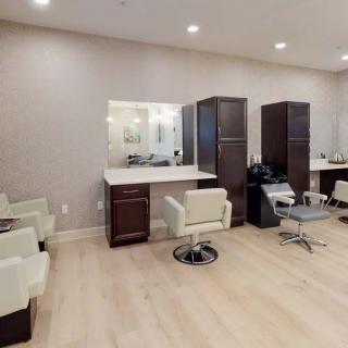 A modern salon interior with styling stations, mirrors, and chairs.