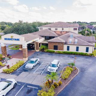 Aerial view of a building with a small parking lot and landscaped surroundings.