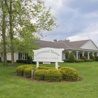 A funeral home with a well-maintained lawn and a sign at the front.