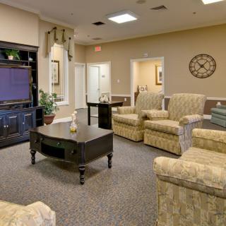 A comfortable living room with plush chairs and a large television.
