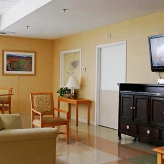 A cozy waiting room with a television, seating area, and light-colored walls.
