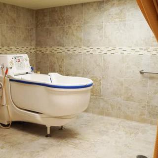 A spacious bathroom equipped with a specialized bathtub designed for healthcare needs.