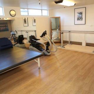 A rehabilitation center therapy room equipped with exercise machines and a therapy table.