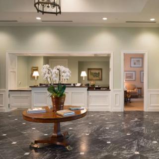 Elegant lobby area with a central table displaying orchids and ambient lighting.