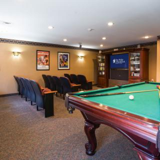 A cozy entertainment room featuring a billiards table and home theater seating.