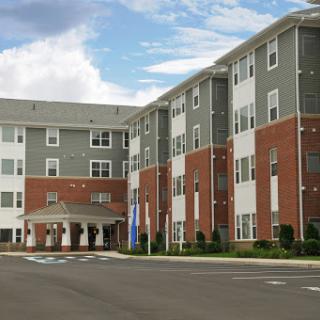A modern multifamily residential building with a blend of brick and siding.
