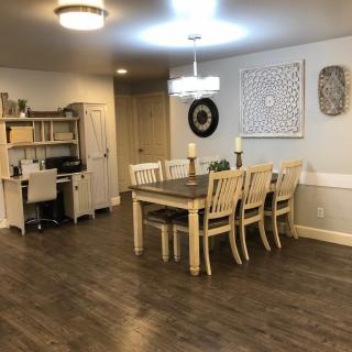 A cozy dining room with a wooden table, chairs, and an adjacent office space.
