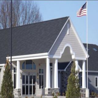 A building with a classic architectural style featuring columns, topped with an American flag.
