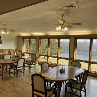 A cozy dining room with large windows offering a scenic lake view.