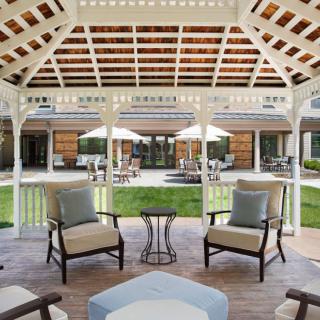 A cozy outdoor gazebo with comfortable seating and a view of the garden.