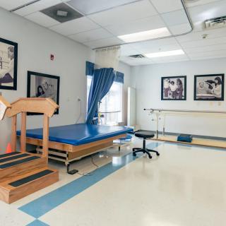A clean and well-equipped physical therapy room with exercise equipment and rehabilitation tools.