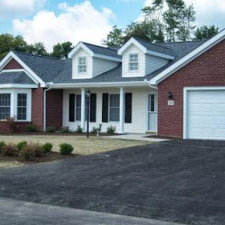 A charming single-story house with a brick exterior and a well-maintained driveway.
