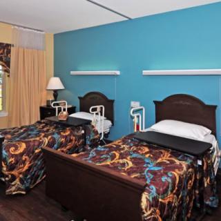 A hospital room with two twin beds and medical equipment.