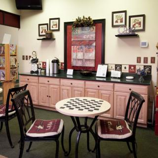 A cozy cafe interior with a chessboard table and a coffee station.