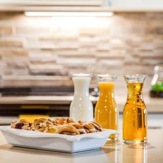 A breakfast setup featuring pastries with carafes of milk and orange juice in a kitchen.