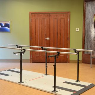 A ballet barre setup in a studio space, featuring multiple bars for training.