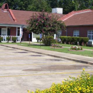 A house with a garden and driveway in front.