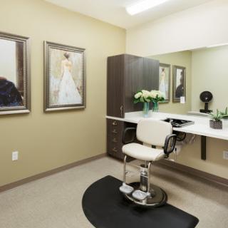 A stylish and organized salon interior featuring a haircut station, decorative artwork, and natural light.