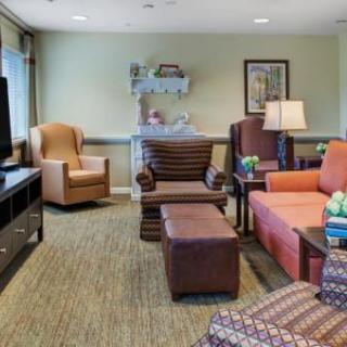 A cozy living room with comfortable seating, a television, and warm lighting.