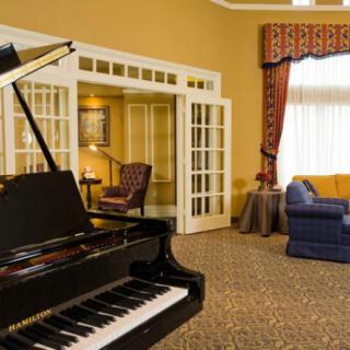 Elegant living room with a grand piano and comfortable seating.
