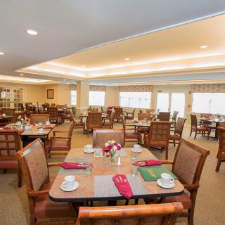 An elegantly set dining area with tables and chairs arranged neatly indoors.