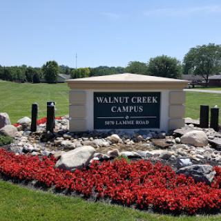 Entrance sign of Walnut Creek Campus surrounded by vibrant landscaping.