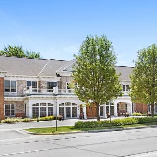 A residential building with trees lined in front, set in a suburban area.