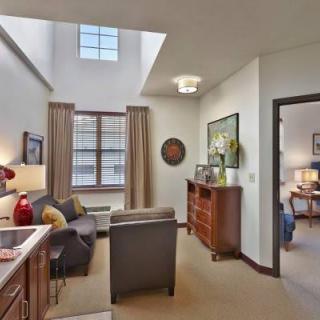 A cozy living room with a skylight, featuring comfortable seating and elegant decor.