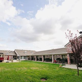 A view of a building with a green courtyard under a cloudy sky.