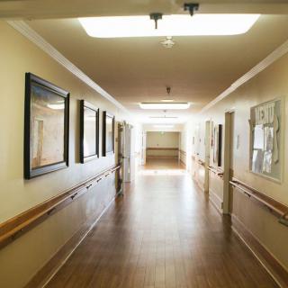 A well-lit, empty hallway with artworks on the walls.