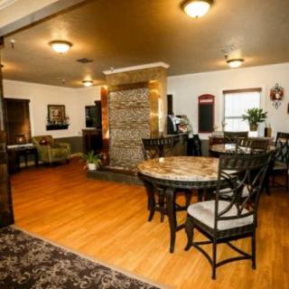 A cozy living room with a dining area, featuring wooden floors and warm lighting.