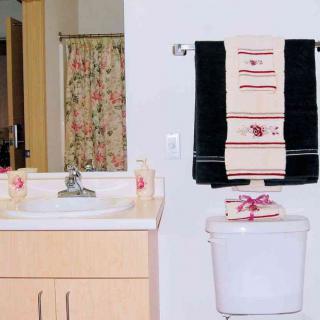 A neatly arranged bathroom with a sink, mirror, and towels.