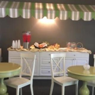 A cozy breakfast buffet setup with a variety of food items displayed under a striped awning.