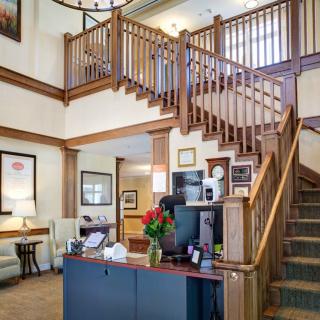 A welcoming lobby area featuring a wooden staircase and a reception desk.
