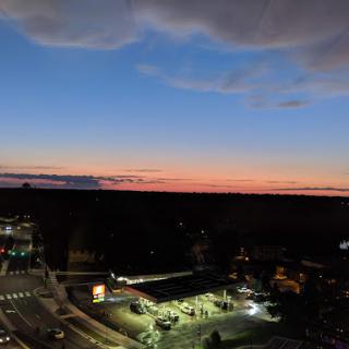 A serene sunset casting warm colors across the sky, as day transitions to night.