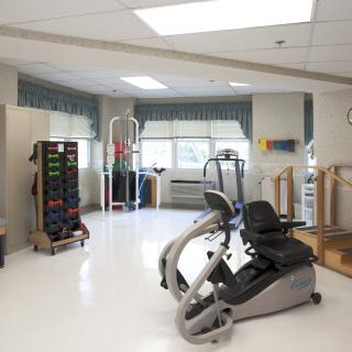 A physical therapy room equipped with various exercise machines and rehabilitation equipment.