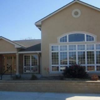 A modern residential house with large windows and a sloped roof.