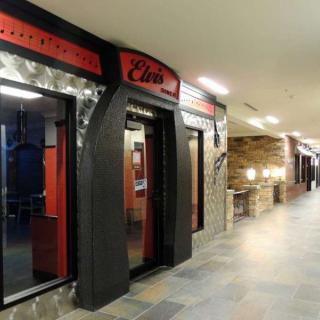 A view of a restaurant entrance in a well-lit corridor.