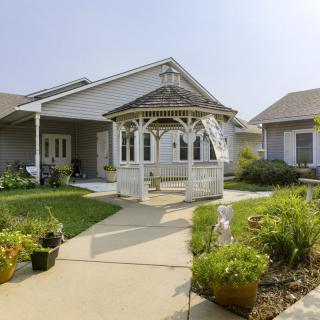 A charming suburban home with a gazebo and well-maintained garden.
