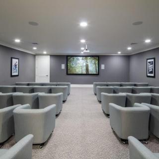 A spacious home theater with comfortable seating and a large screen.
